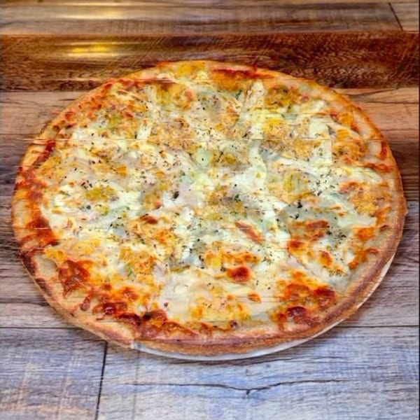A J&J PIZZA RESTAURANT white pizza with a golden crust on a rustic wooden table.